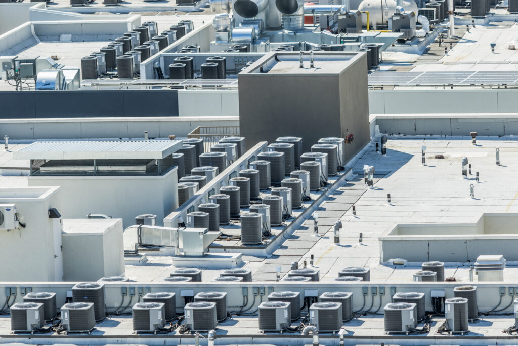 An array of air conditioning units on a commercial building roof.