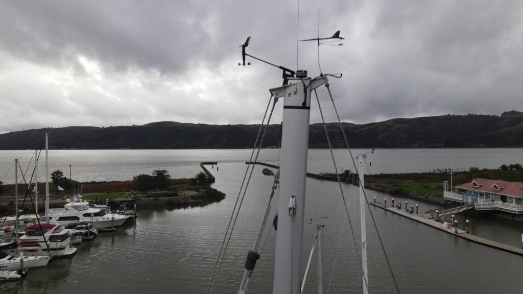 Marina view from atop a boat mast with overcast skies.